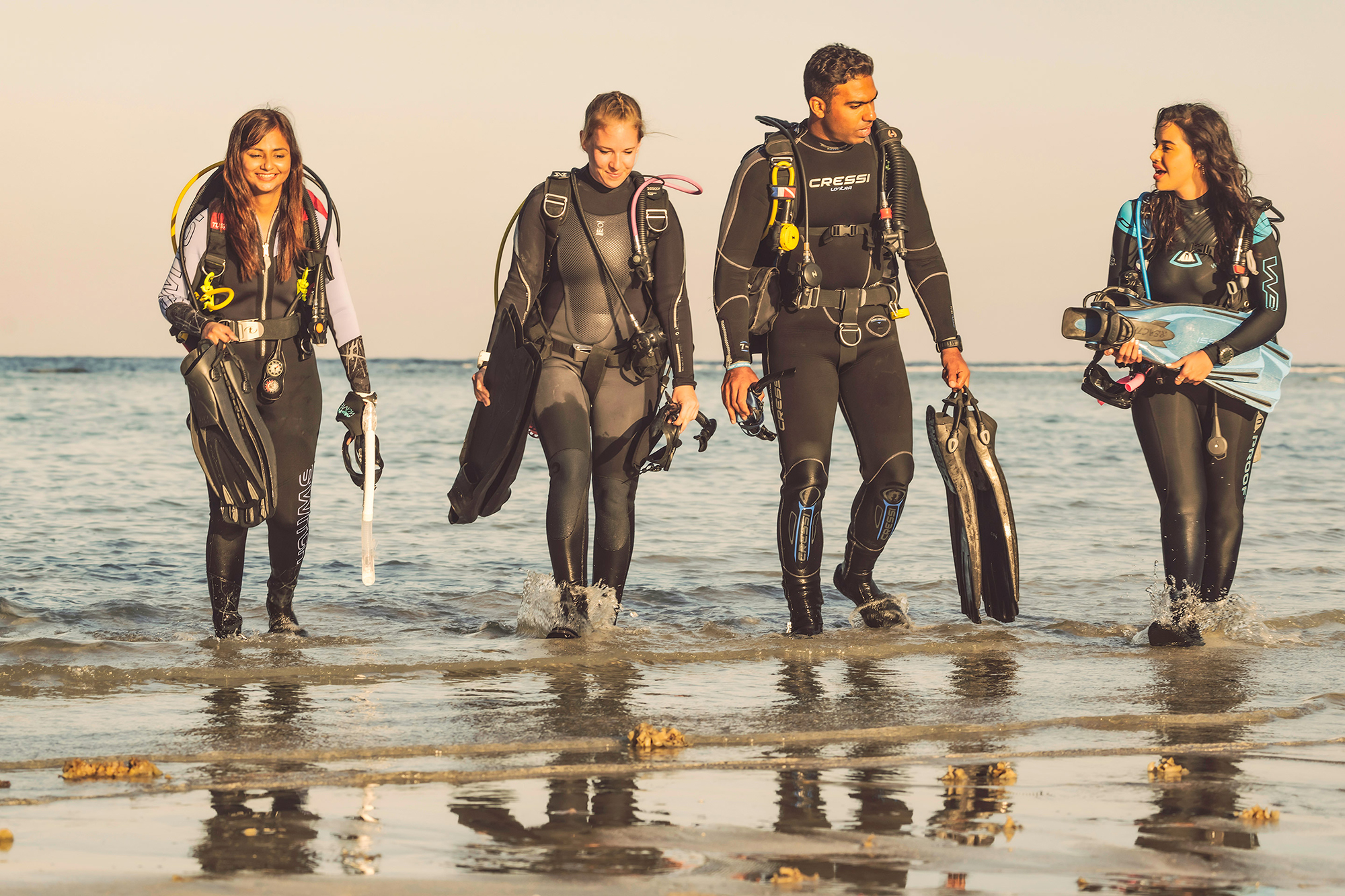 Scuba divers walking out of water of Cabo San Lucas after their PADI IDC training